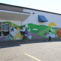 artist painting mural on wall